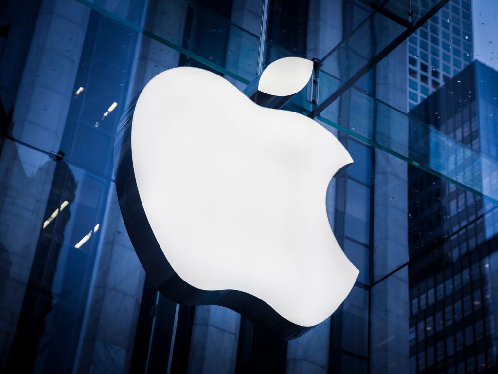 The apple logo is seen in front of a building.